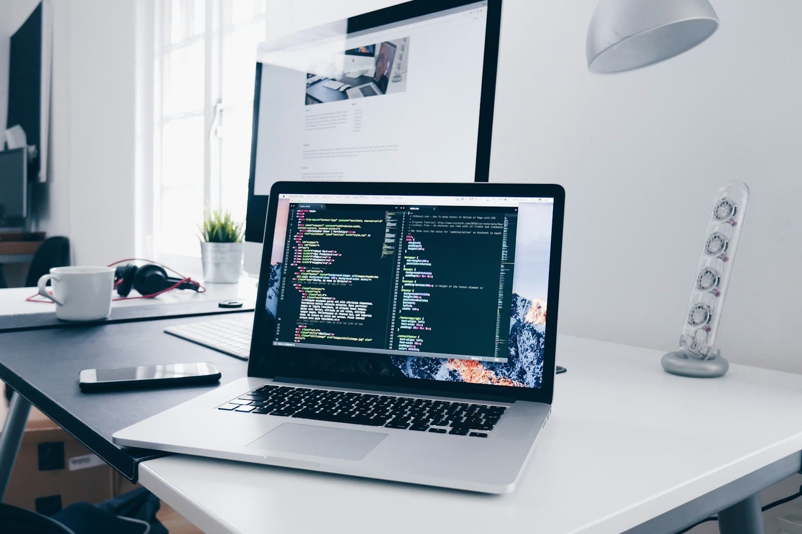 Laptop on a desk showing source code